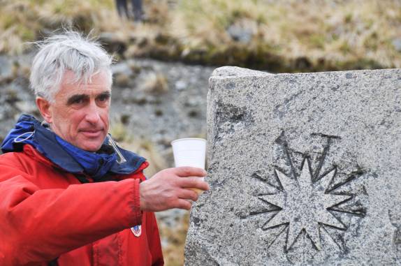 O nosso guia de história, Damien, faz um brinde a Ernest Shackleton no cemitério onde ele está enterrado, em Grytviken, na Geórgia do Sul (foto de Susan Pairaudeau)